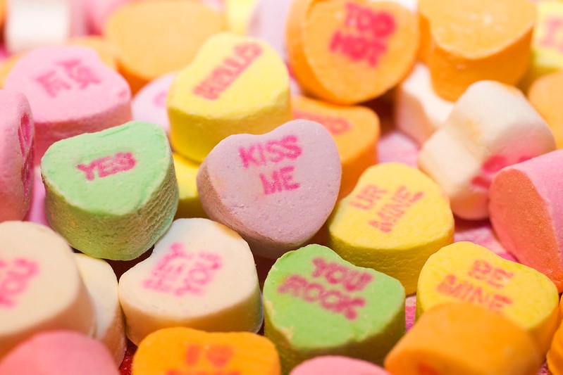 A group of small colorful candied hearts that each display a different term of endearment. 